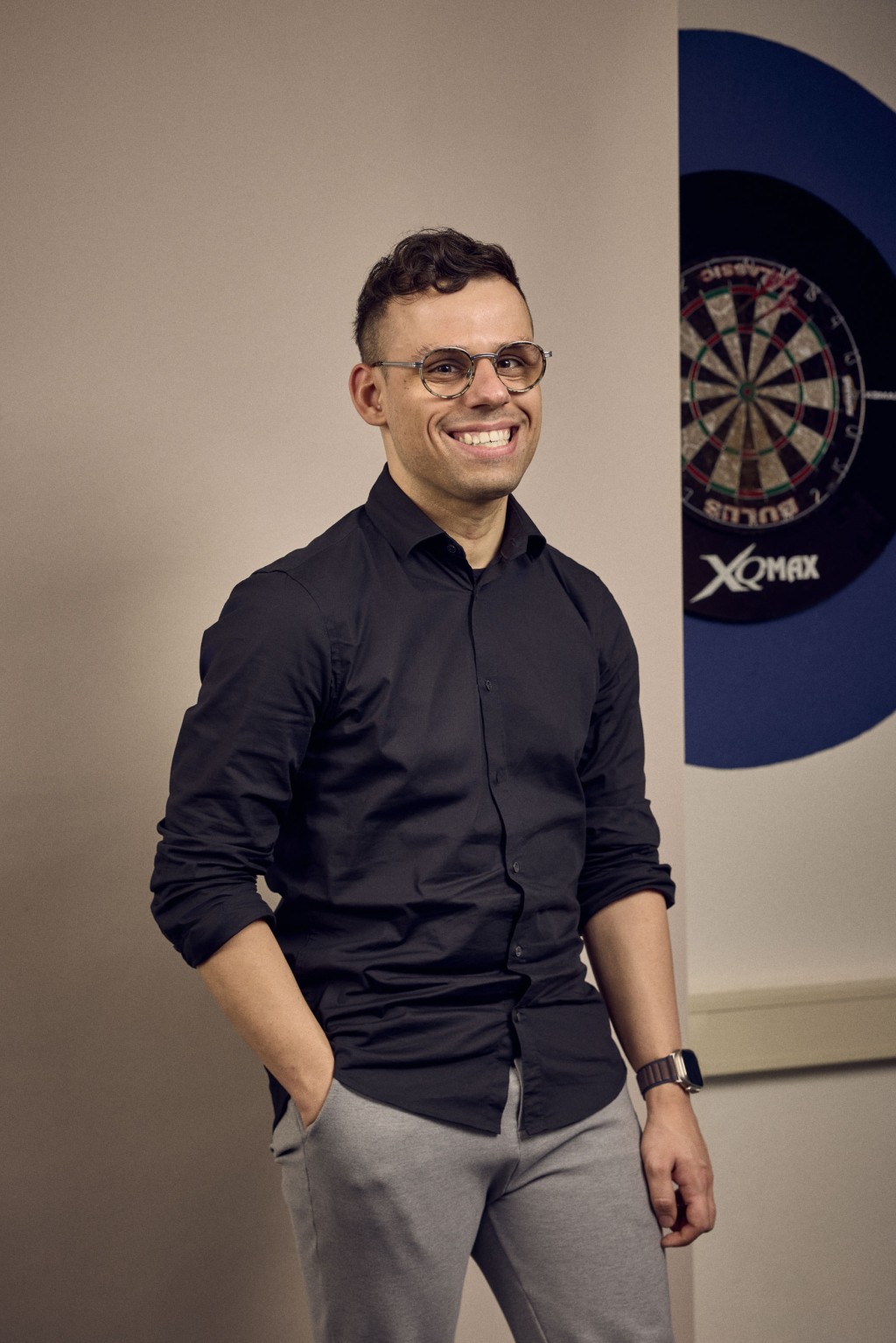 Jordy Arntz staat voor een bronzen backdrop met een dartbord achter zich.