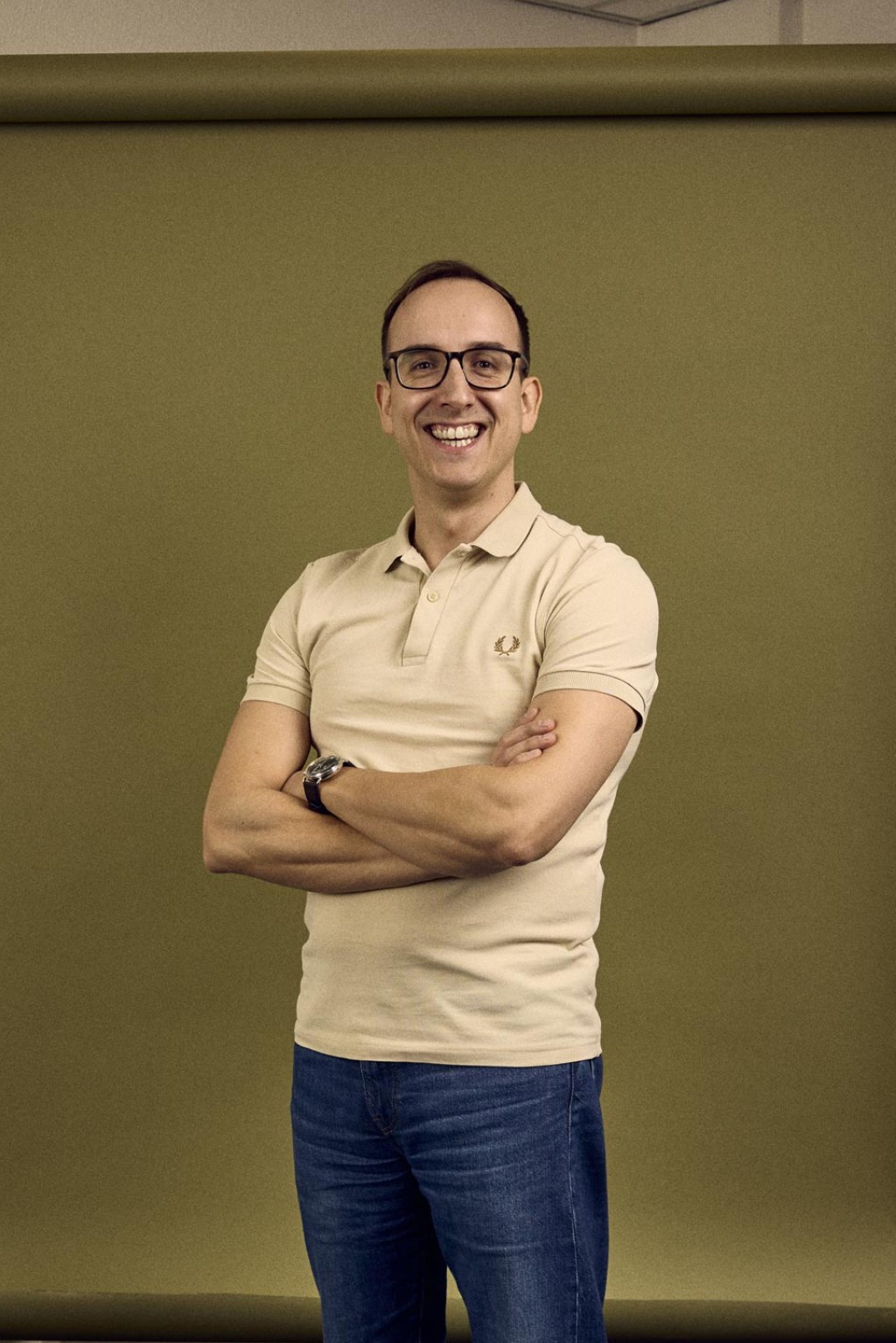 Paul Cremers staat in een kantoorruimte voor een groene backdrop.