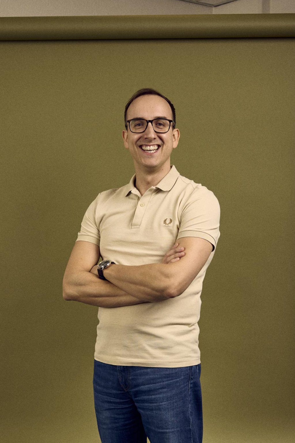 Paul Cremers staat in een kantoorruimte voor een groene backdrop.