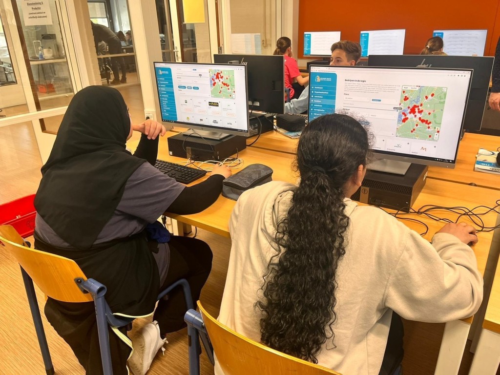 Twee studenten die zich aan het aanmelden zijn op de site van Regio in je Rugzak op een school.