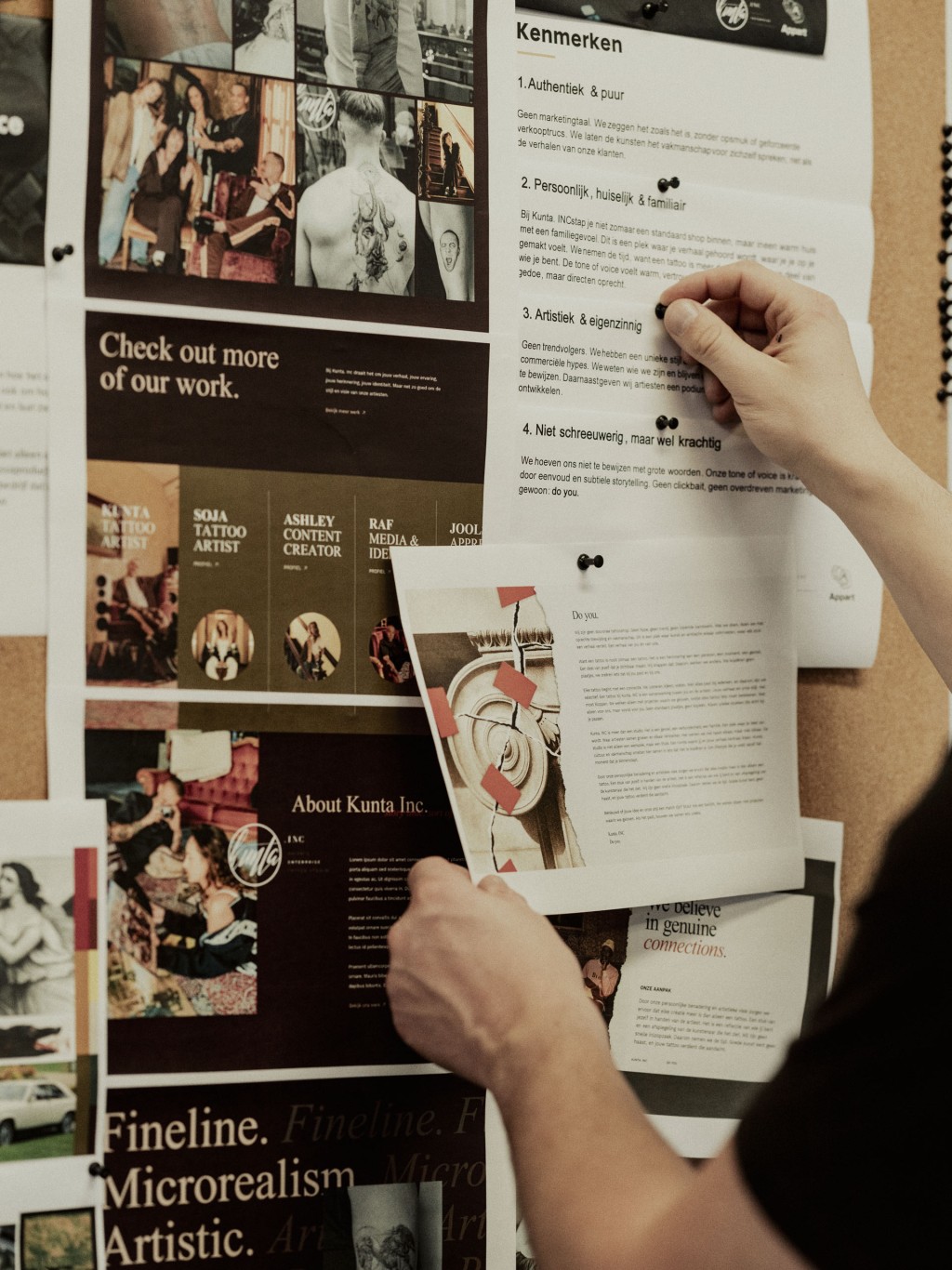 Iemand hangt een poster op een prikbord vol flyers en afbeeldingen.